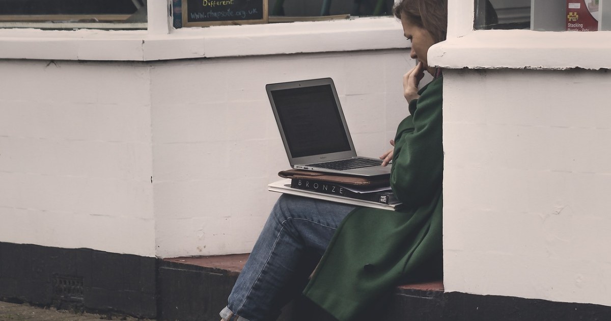 Laptop and research materials for an AI research tools guide.