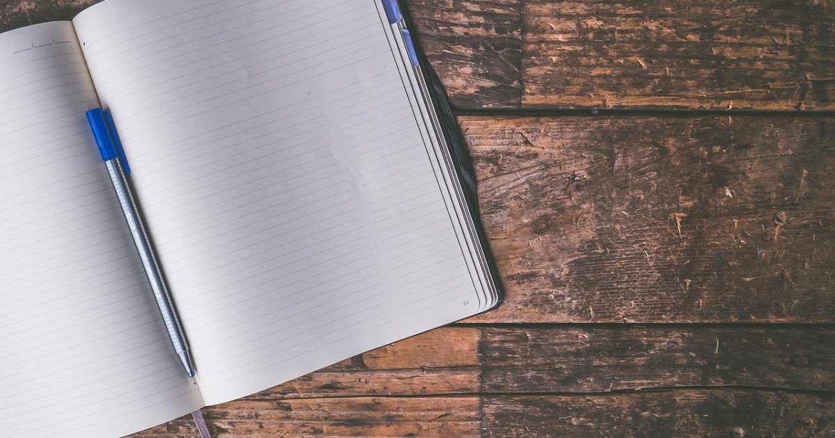 Laptop and notebook for an AI writing tools comparison.