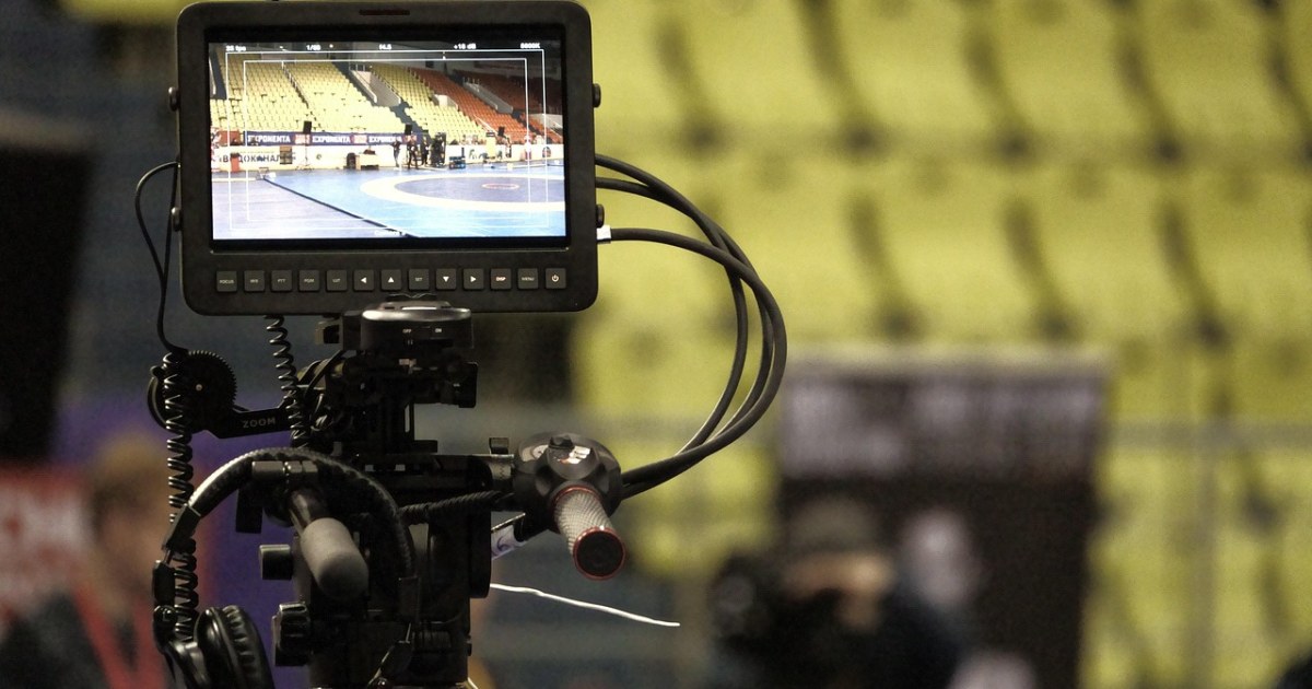 Sports stadium and camera scene for a sports documentary guide.