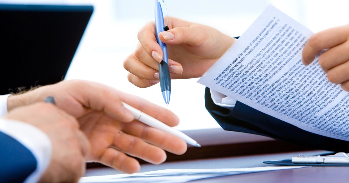 Business documents and laptop for a client handoff system guide.