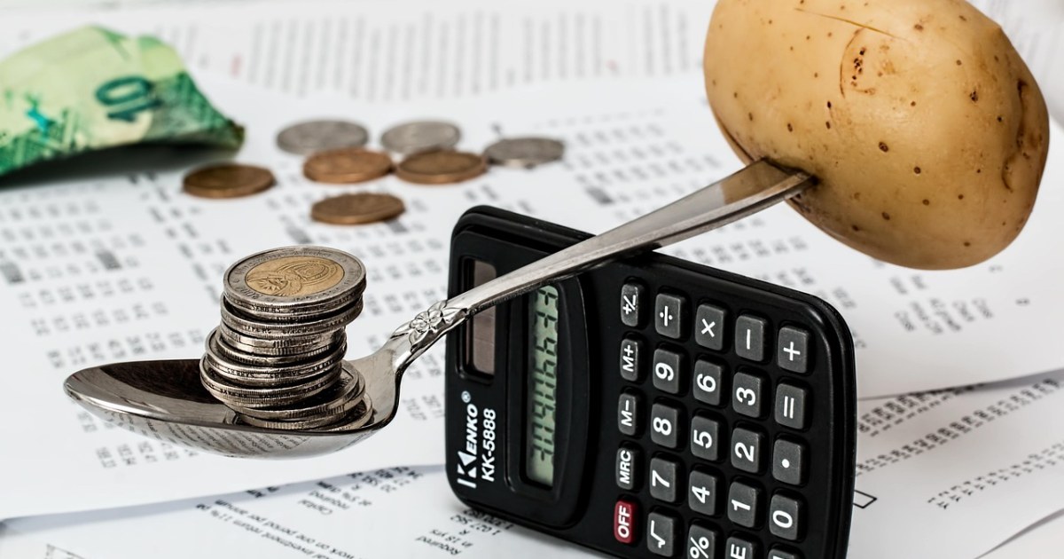 Coins and calculator for a travel budget planning guide.