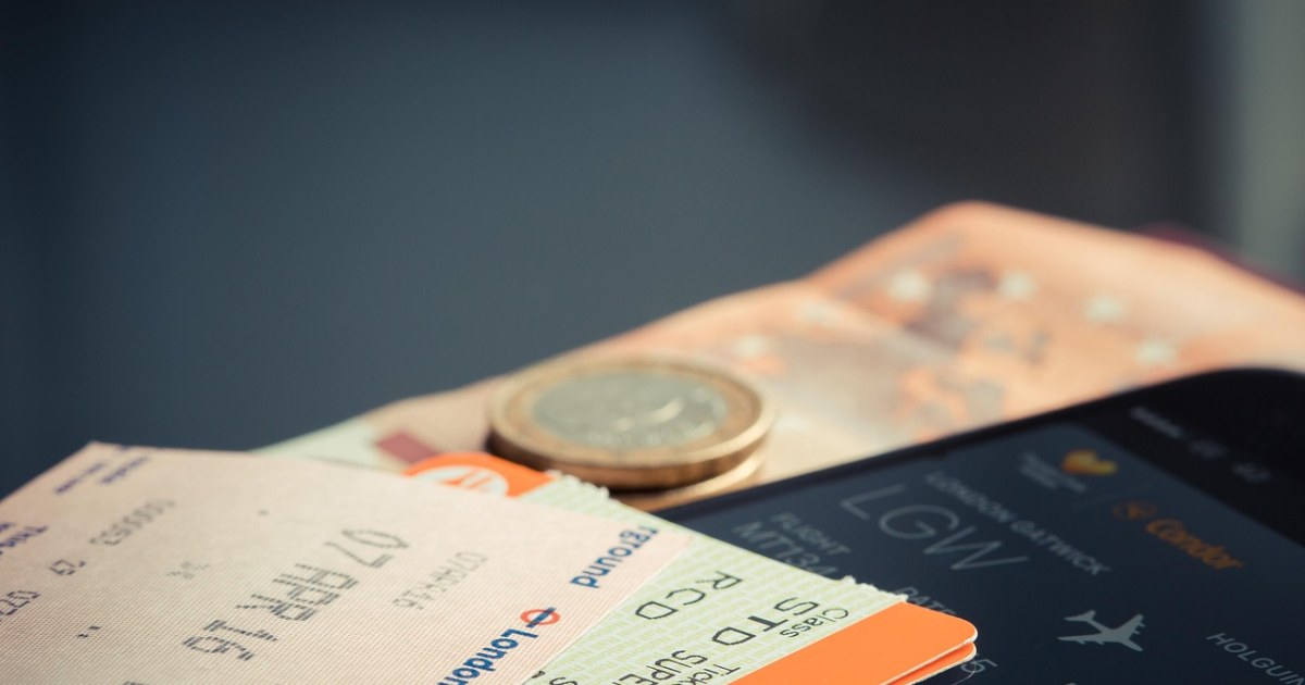 Travel tickets, coins, and phone for a pass and bundle value guide.