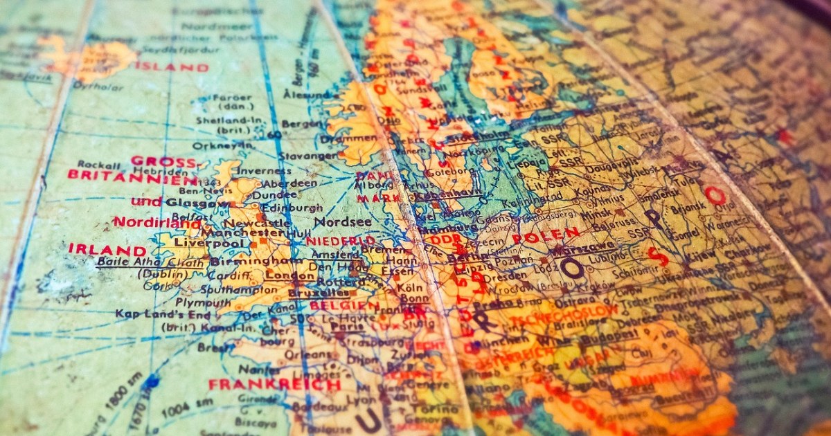 Smartphone on a travel map for a Europe eSIM versus roaming pass cost comparison.