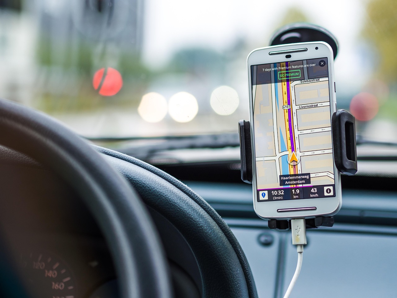 A smartphone displaying a navigation map on a car dashboard