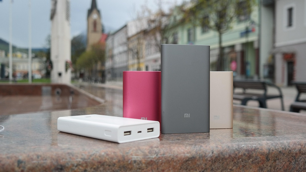 Several portable power banks photographed on a ledge outdoors in a city