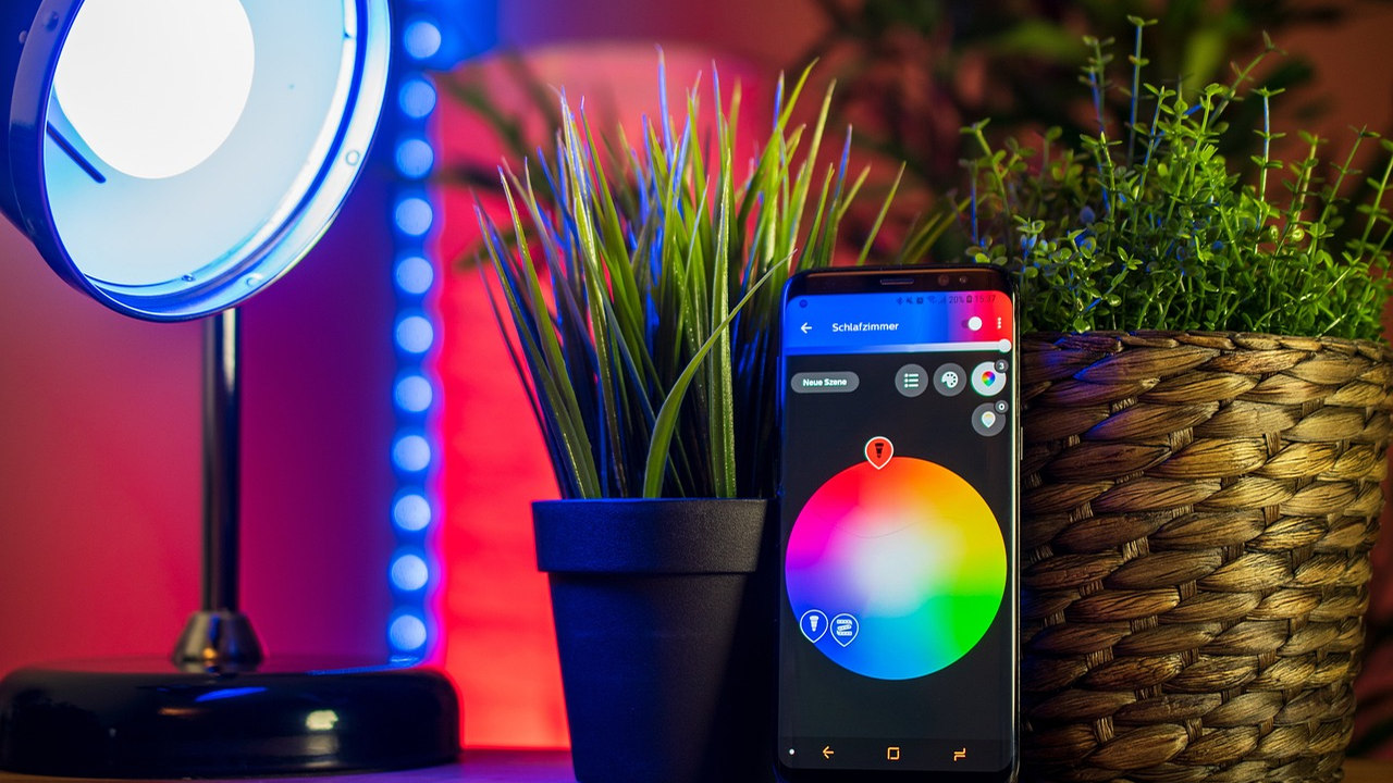 Smartphone controlling colorful smart lighting in a home setting